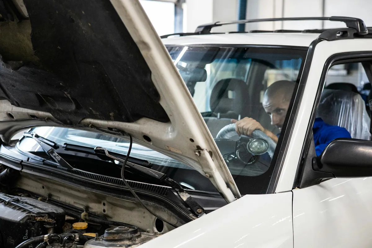 A technician working on a vehicle in a service bay